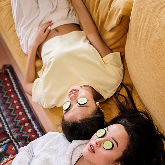 Mujeres con tratamiento para el contorno de los ojos con rodajas de pepino