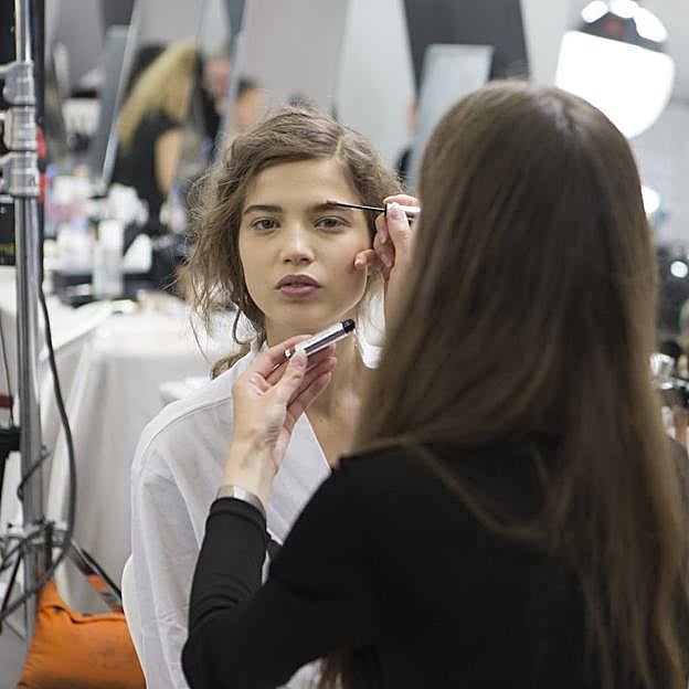 Profesional aplicando sérum de cejas a modelo