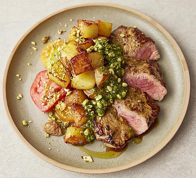 El solomillo a las hierbas y patatas crujientes, pesto verde, ensalada de tomates de colores y pistachos picados de 5 Ingrediente sMediterráneos, el nuevo recetario de Jamie Oliver.