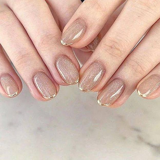 Uñas en tonos dorados con efecto gloss
