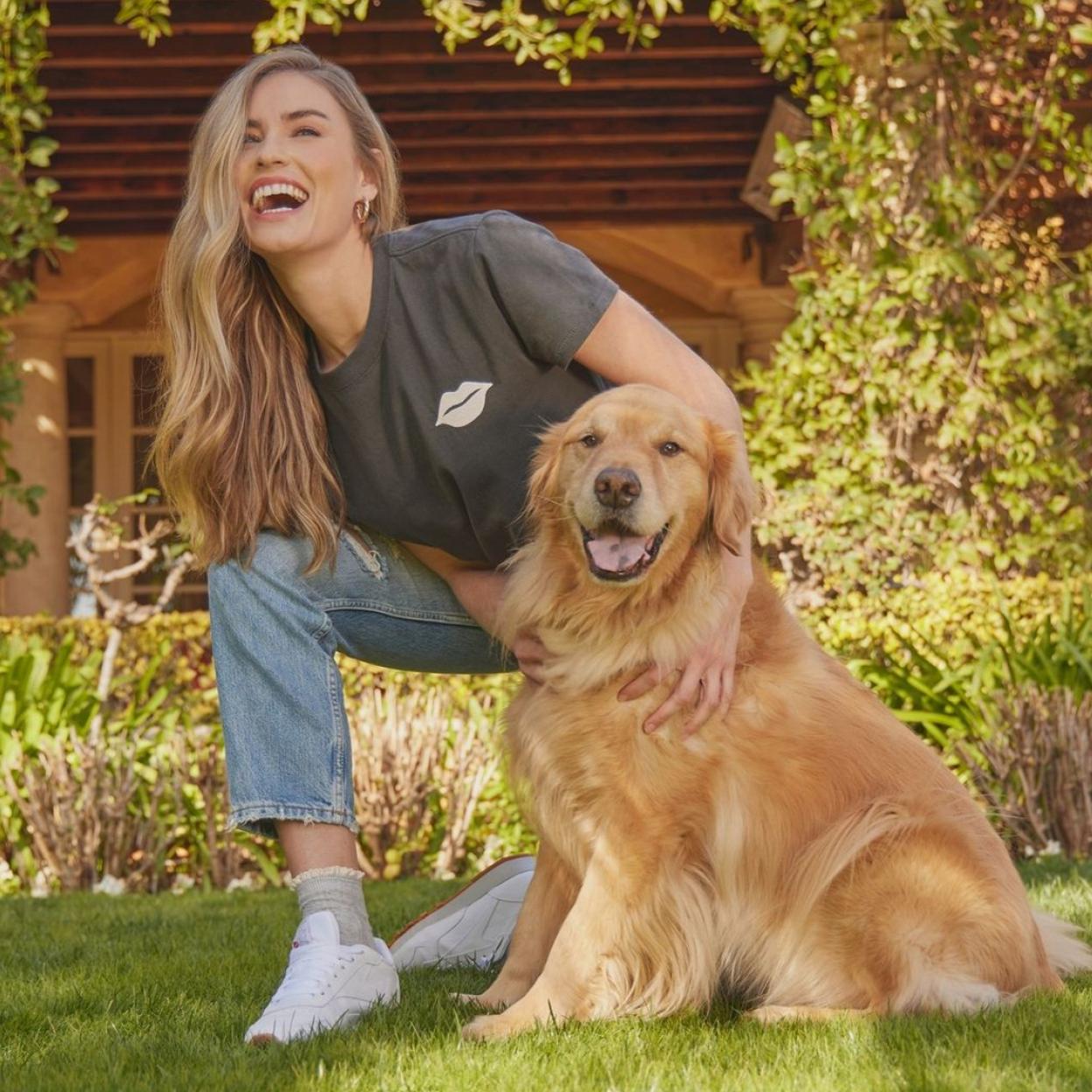 Mujer sonriendo junto a un perro en una foto promocional de la firma Wildfox. 