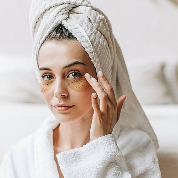 Mujer con parches de hidrogel en el contorno de los ojos