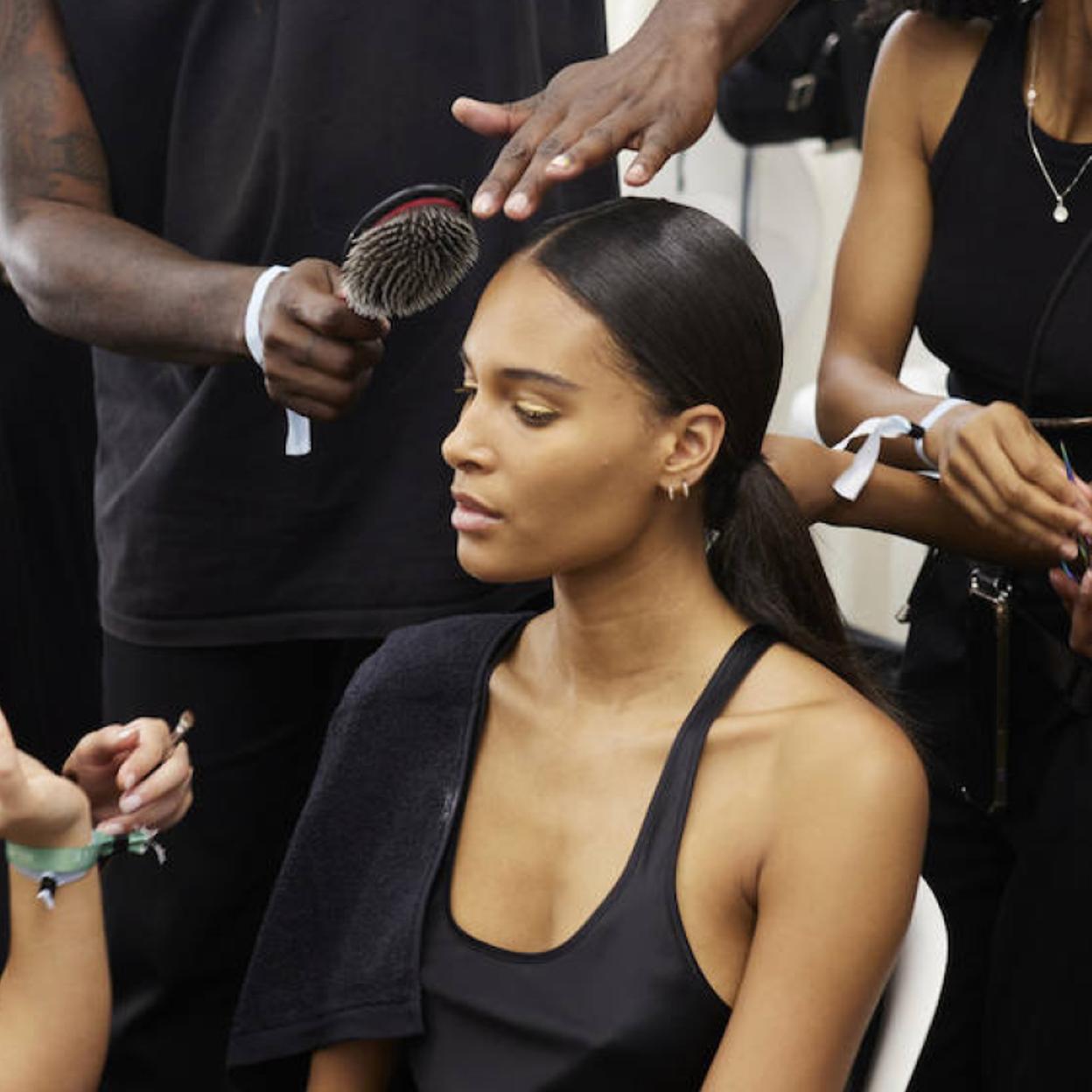 Peluquero profesional usando cepillo con cerdas de jabalí en modelo