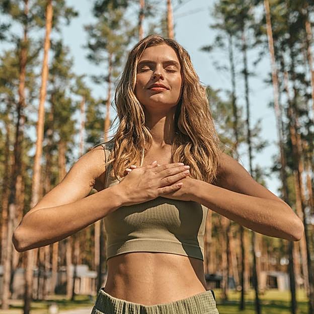 Mujer respirando en plena naturaleza. 