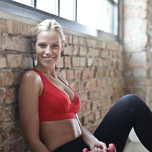 Mujer en el gimnasio descansando después de hacer deporte.