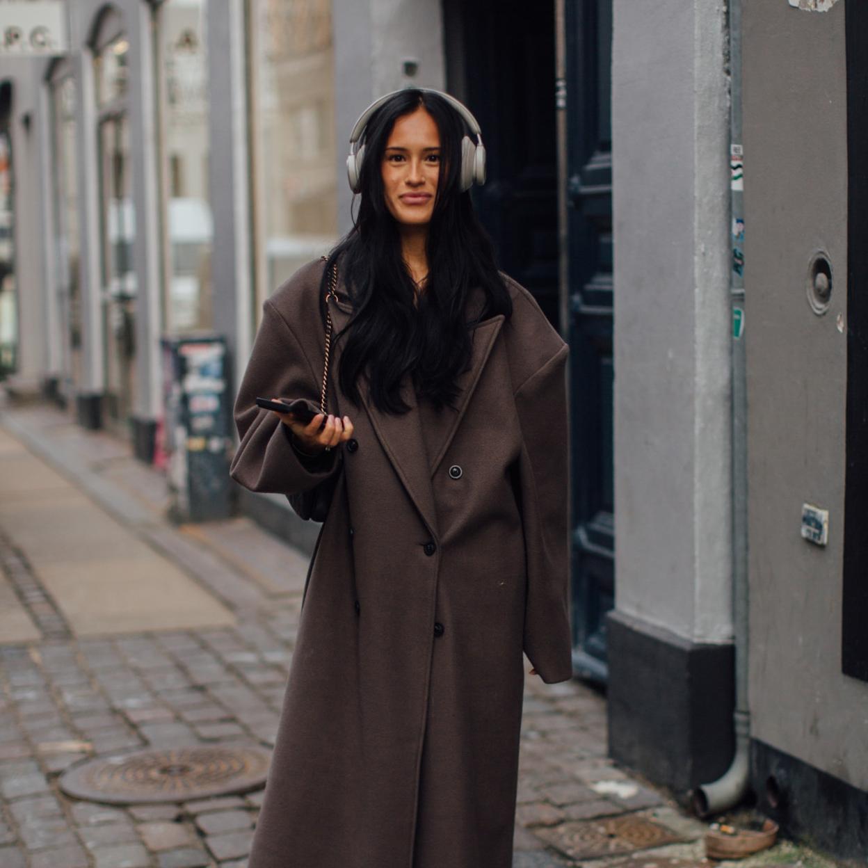 Una mujer con abrigo en marrón chocolate.
