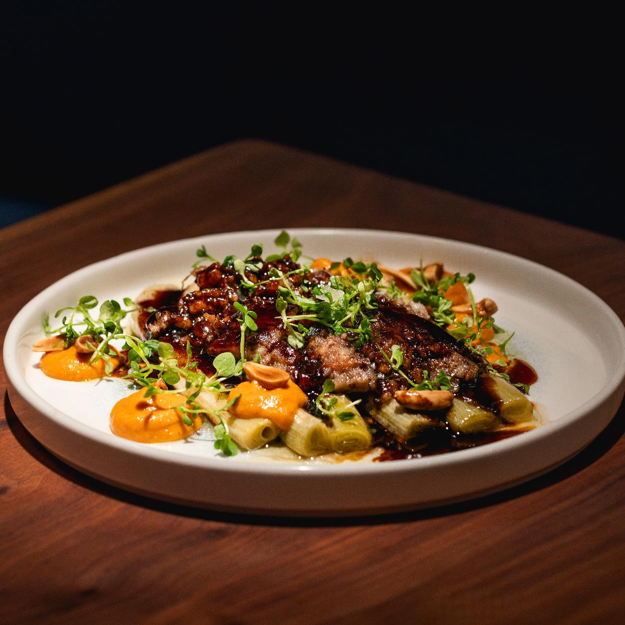 Los calçots confitados a baja temperatura de Barra Alta, un plato que recrea la experiencia de la calçotada al completo.