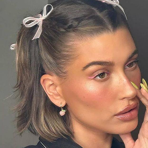 Hailey Bieber con peinado para pelo corto estilo coquette con lazos