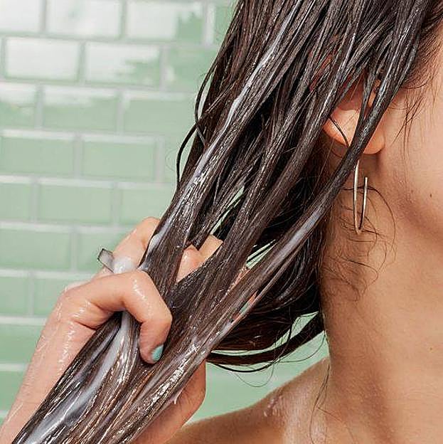 Mujer usando mascarilla de pelo