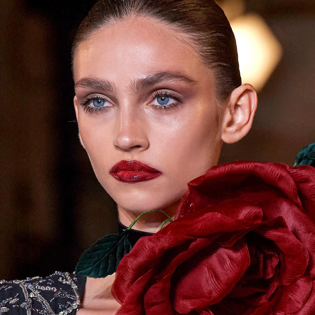 Una modelo con un maquillaje de labios rojos.