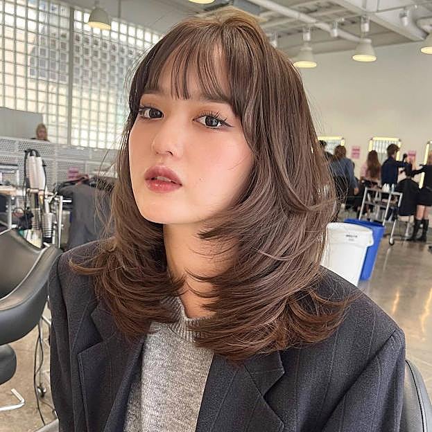 Influencer con corte kitty cut combinado con flequillo recto