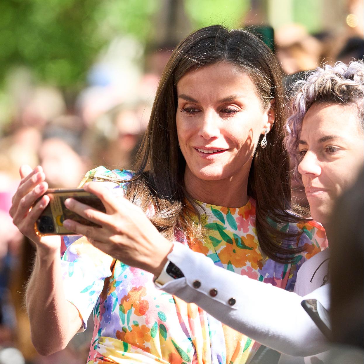 La reina Letizia posa para un selfie con una persona del público.