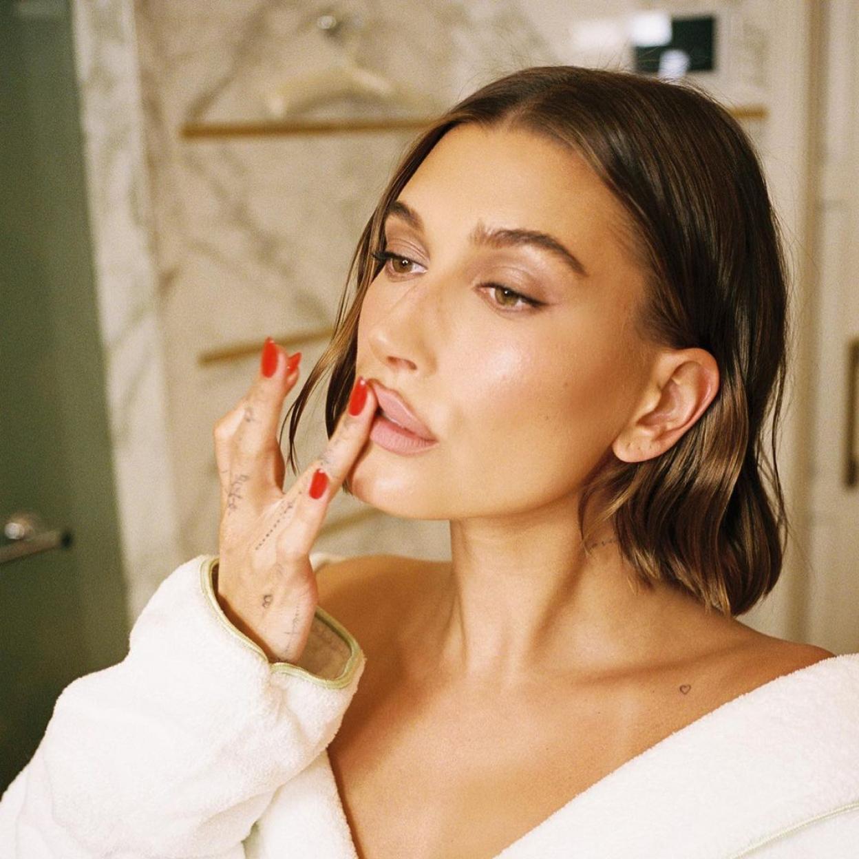 Hailey Bieber posando con uñas rojas