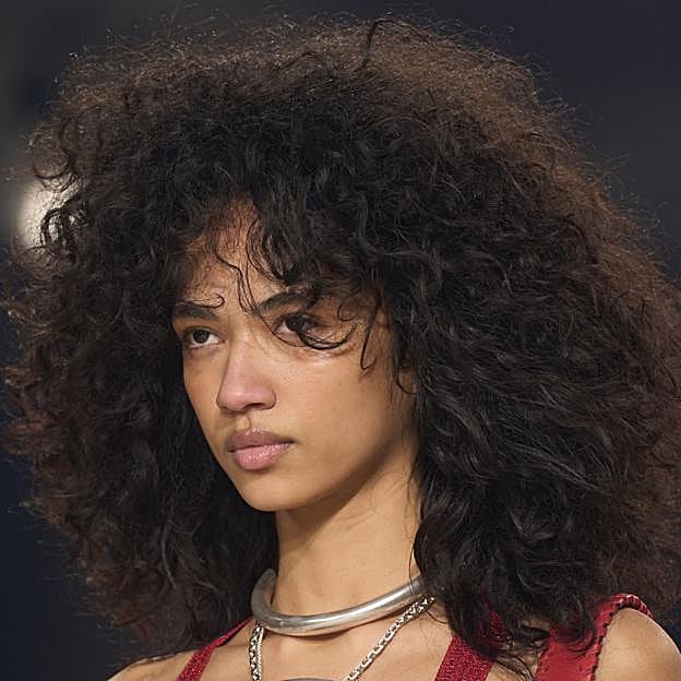 Una modelo con el pelo rizado