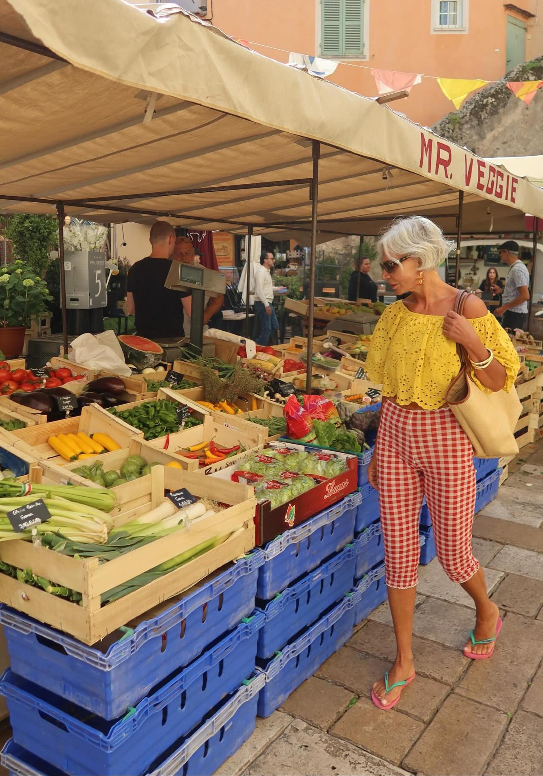 Mujer comprando frutas y verduras en el mercado. 