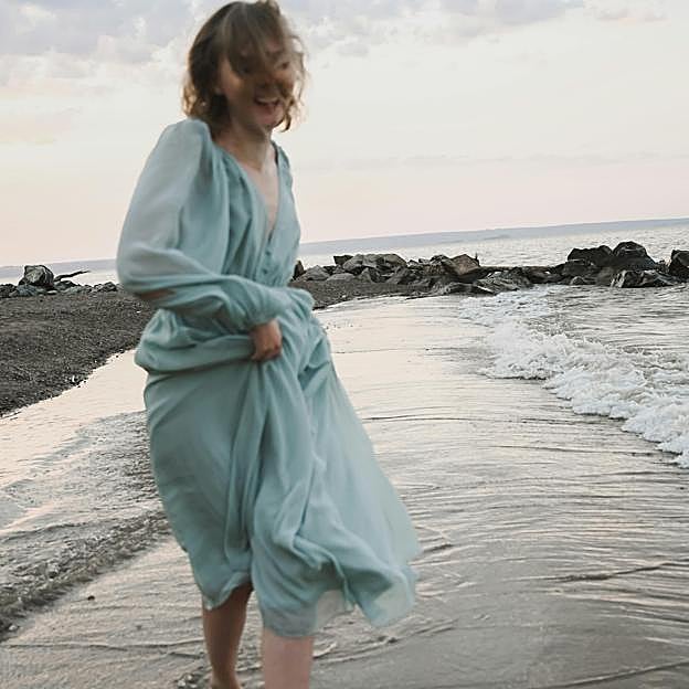 Mujer disfrutando de una caminata en la playa. 