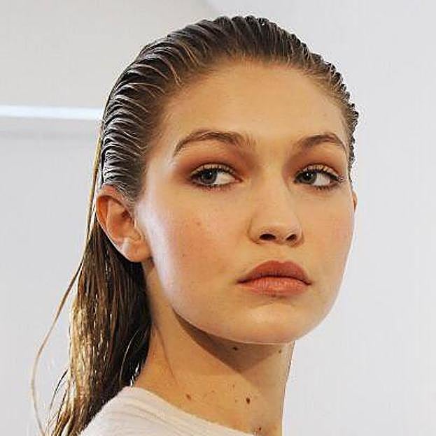 Gigi Hadid con peinado efecto mojado con pelo suelto hacia atrás