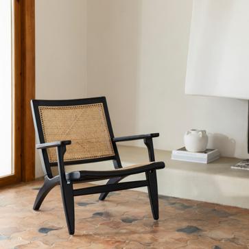 Imagen secundaria 1 - La original mesa auxiliar es de la colección de Zara Home x La Collagerie y cuesta 99.90 euros. La butaca de madera y rafia es el modelo Java de Kenay (329 euros) y la estantería Daman es de Sklum y cuesta 169.95 euros.