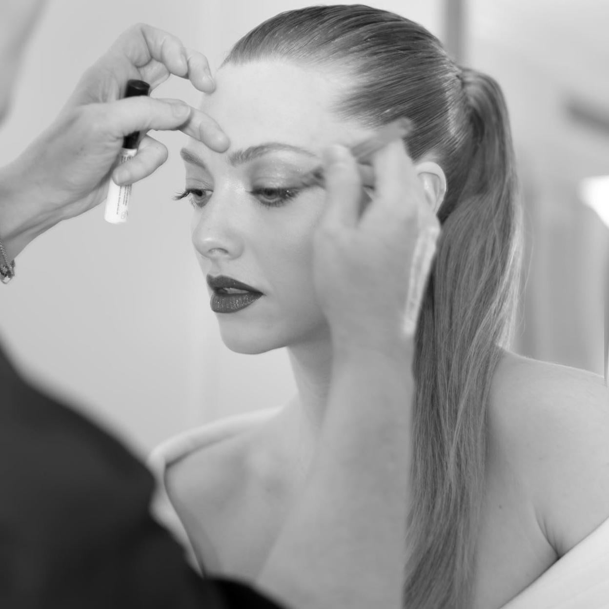 Amanda Seyfried maquillándose los ojos.