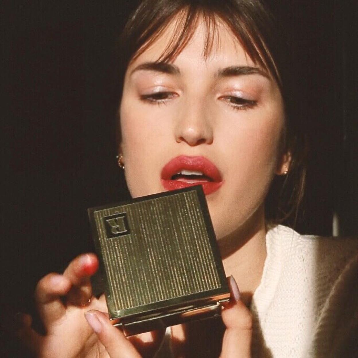 La influencer francesa Jeanne Damas pintándose los labios de rojo.