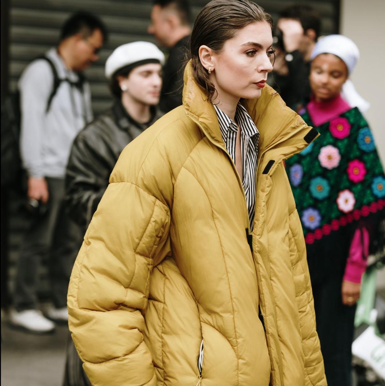 Una modelo con un plumífero de color amarillo.