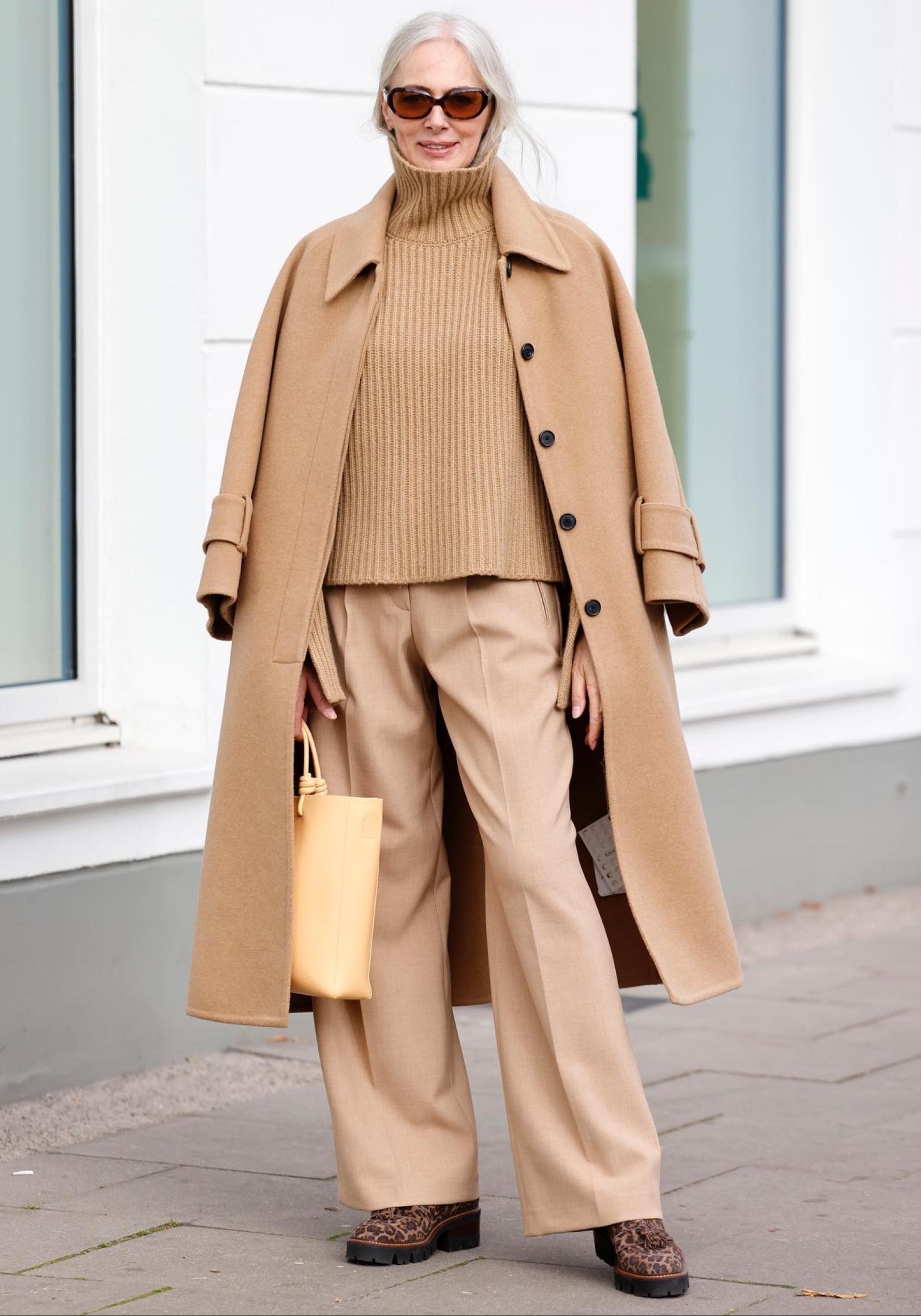 Una ifluencer de más de 50 con un abrigo largo camel.