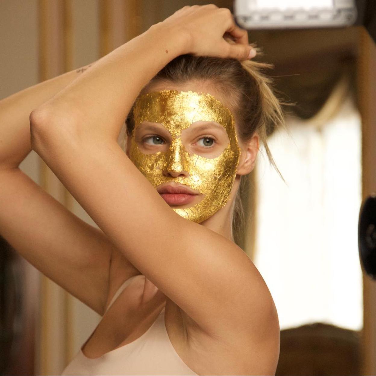 Una modelo con una marscarilla facial con oro.