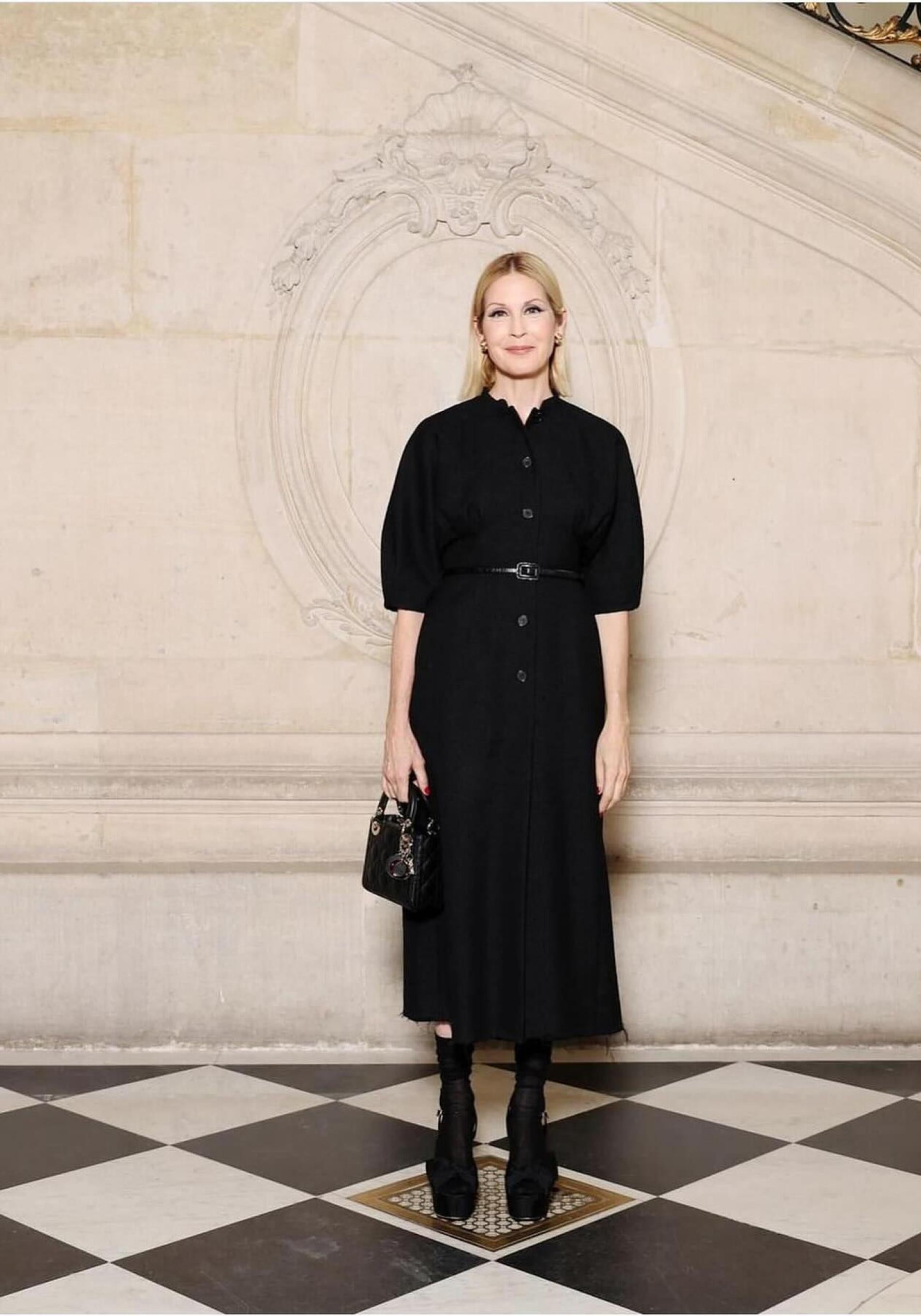 Kelly Rutherford con vestido negro midi elegante a los 50