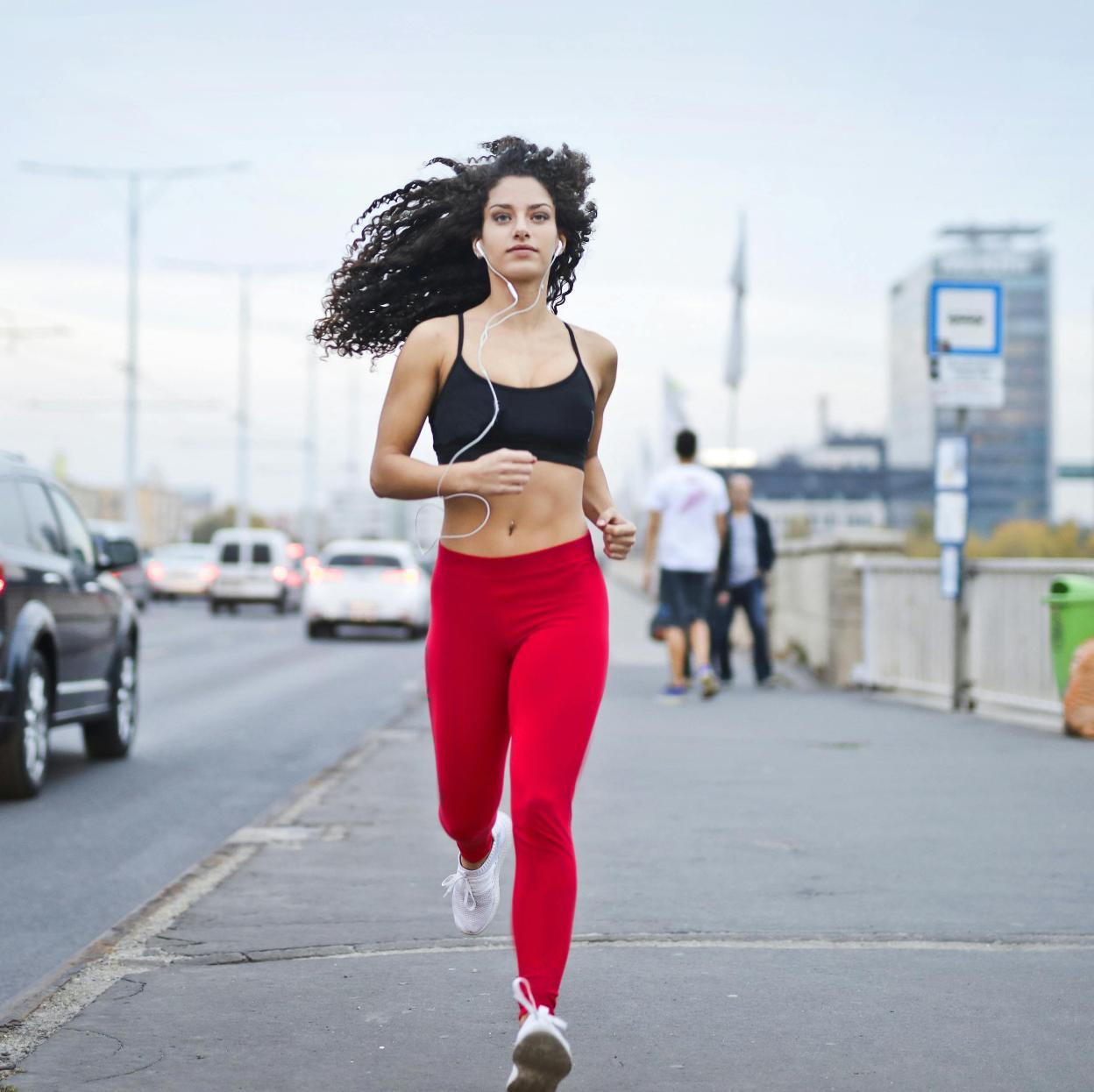 Mujer corriendo por una ciudad. 