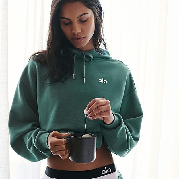 Mujer tomando un té antes de entrenar. 