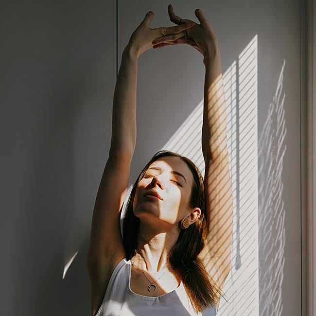 Mujer realizando estiramientos de triceps.