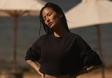 Mujer con un look deportivo en la playa.