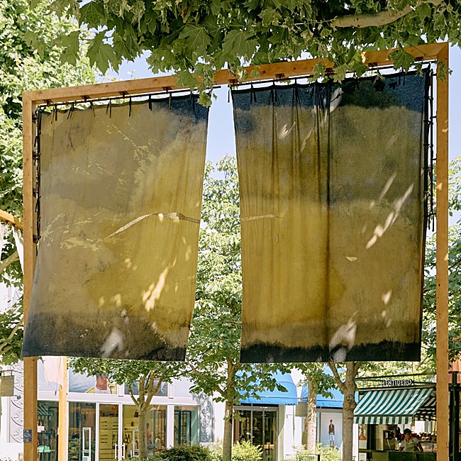 El amarillo de estas telas que cuelgan de Las Rozas Village sale de la gardenia.