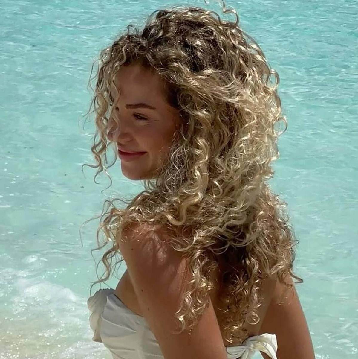 Influencer con cabello rizado en la playa