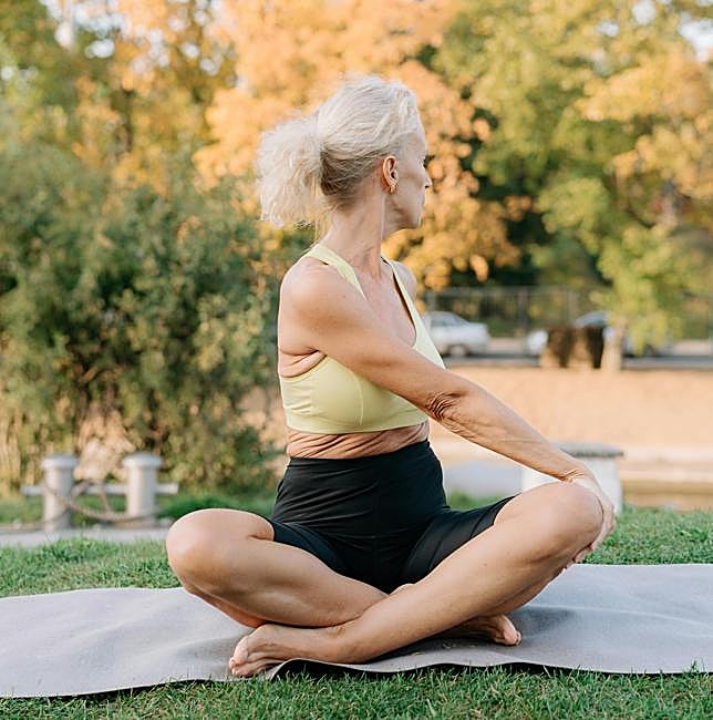 Mujer practicando yoga al aire libre.