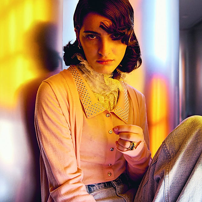 Top y cárdigan de punto, de Rabanne; blusa lencera, de Woman fiesta en El Corte Inglés; pantalón vaquero, de Guess, y pendientes y anillos, de Tous.