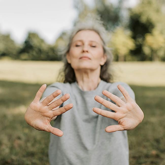 Mujer meditando al aire libre.