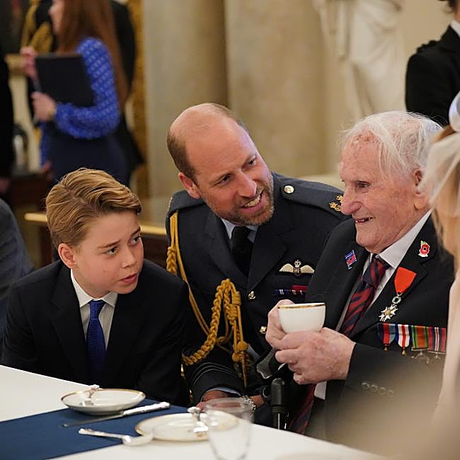 El príncipe George y su padre, Guillermo de Inglaterra tomando el té con los veteranos en un acto de Buckingham Palace.
