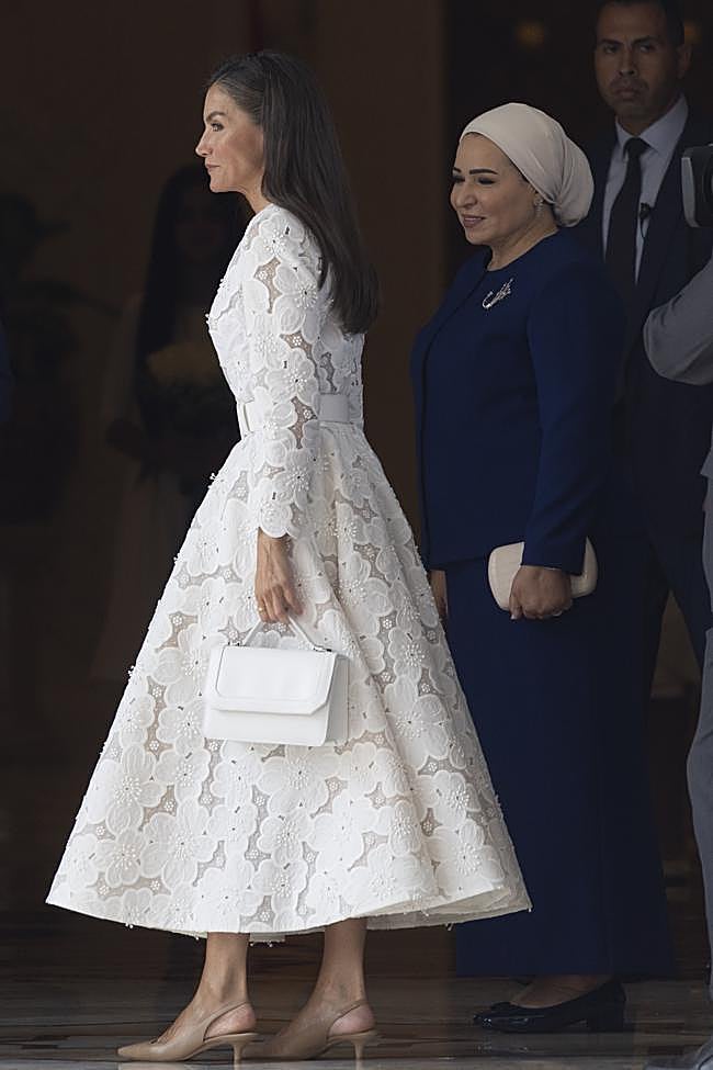 La reina Letizia añadió un bolso blanco y zapatos nude.