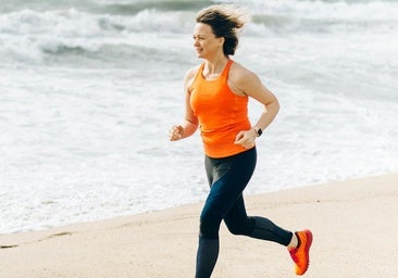 Mujer corriendo por la playa.