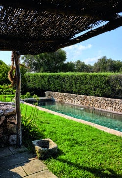 Imagen secundaria 2 - Blanca Miró en el salón exterior. El jardín es obra de la paisajista francesa Anne Eglise. La piscina exterior a modo de alberca es de agua salada.