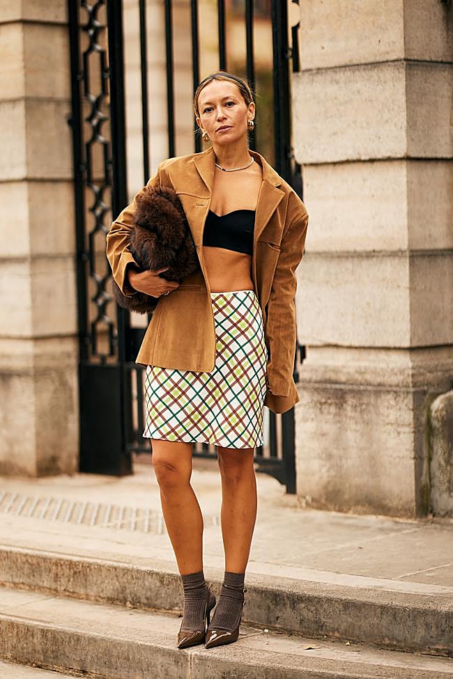 Mujer con falda estampada y chaqueta de ante