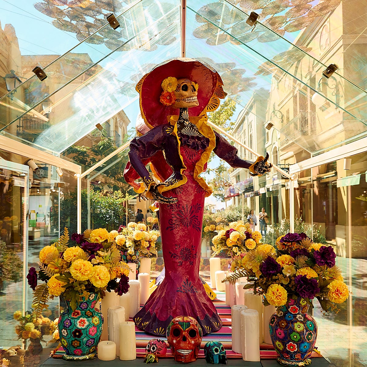 La Catrina luce en todo su esplendor rodeada de flores y toda la parafernalia.