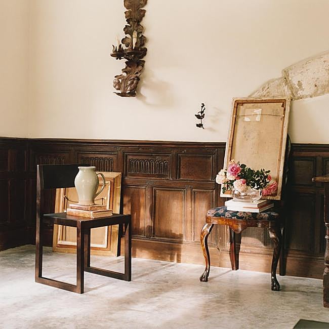 La silla de color oscuro con estructura de madera, asiento y respaldo de piel cuesta 299 euros. El jarrón de cerámica verde, 39.99 y el de cristal irregular, 25.99 euros.