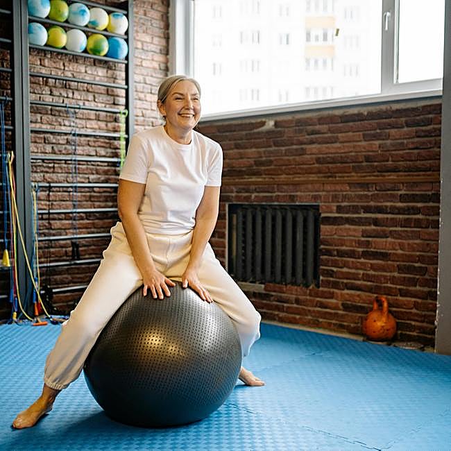 Mujer haciendo ejercicio de Pilates con pelota.