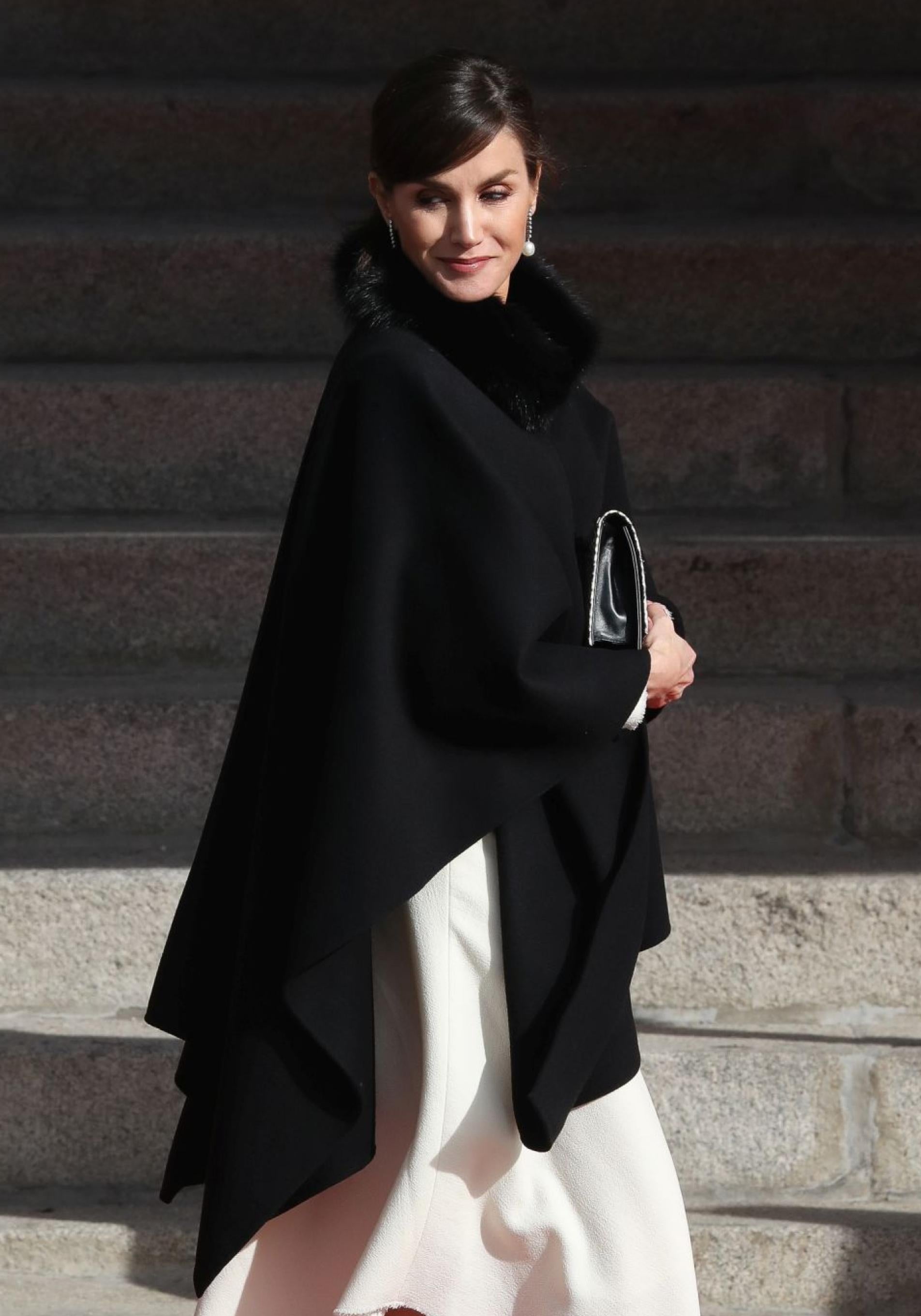 La reina Letizia con una capa negra.