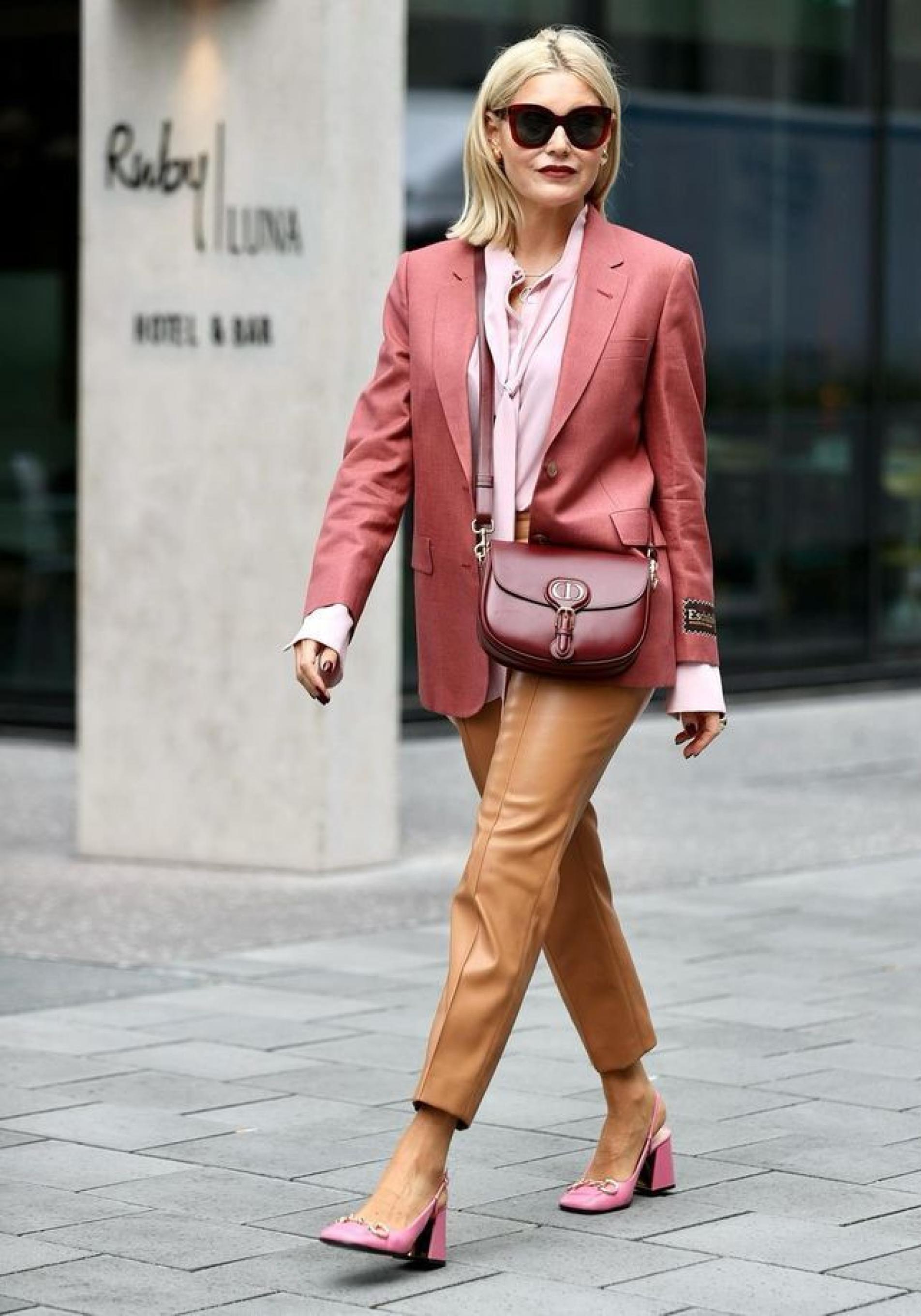 Influencer mayor de 50 con pantalones marrones efecto piel