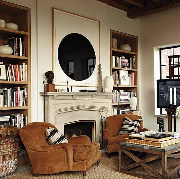 En el salón, junto a la chimenea y las estanterías empotradas de roble, se ha colocado la televisión sobre un caballete de pintor. La mesa es de Lucca Antiques, una tienda de antigüedades de Los Ángeles; el taburete, africano, y la lámpara de suelo, de principios del siglo XX.