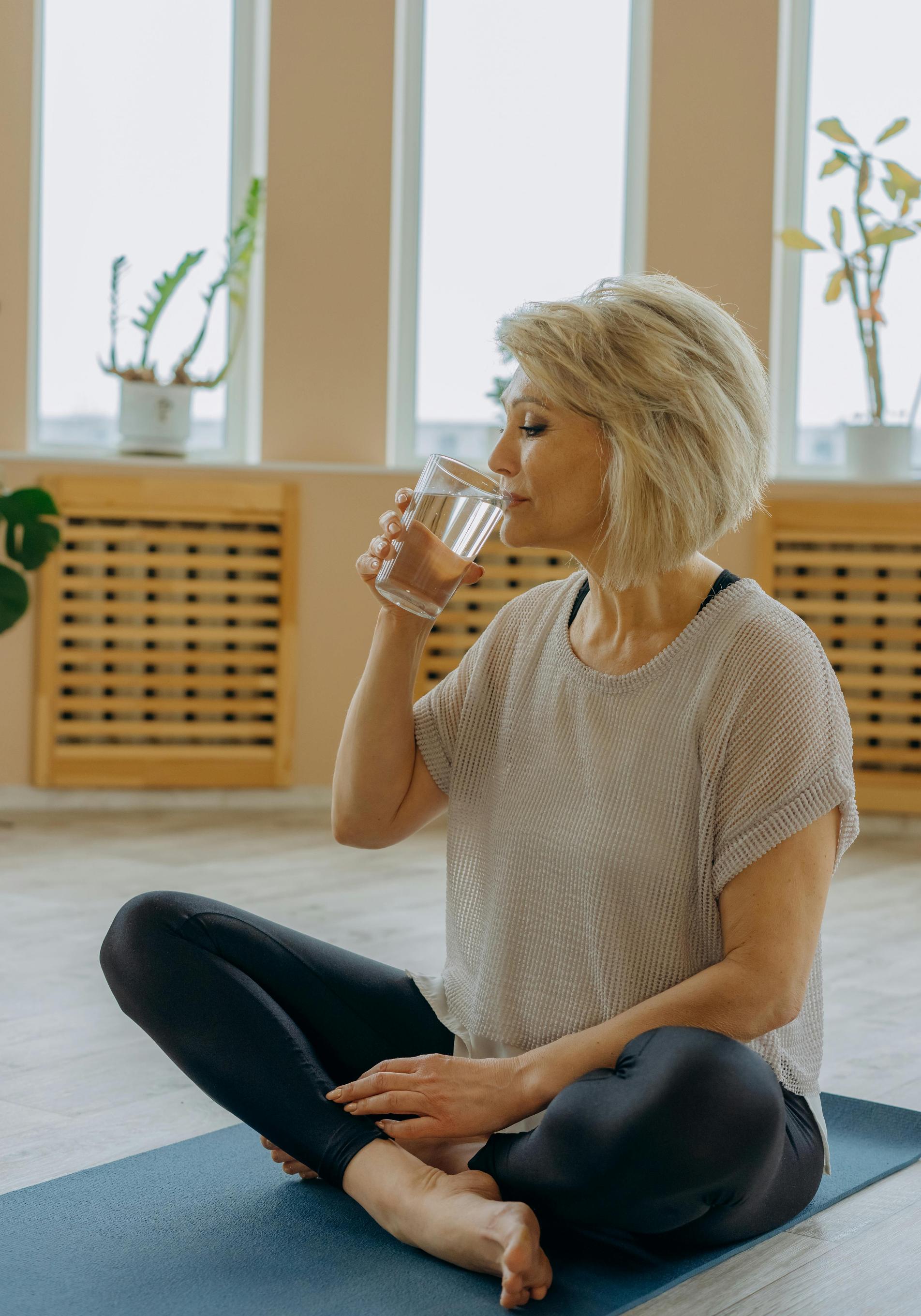 Mujer practicando yoga sobre esterilla. 