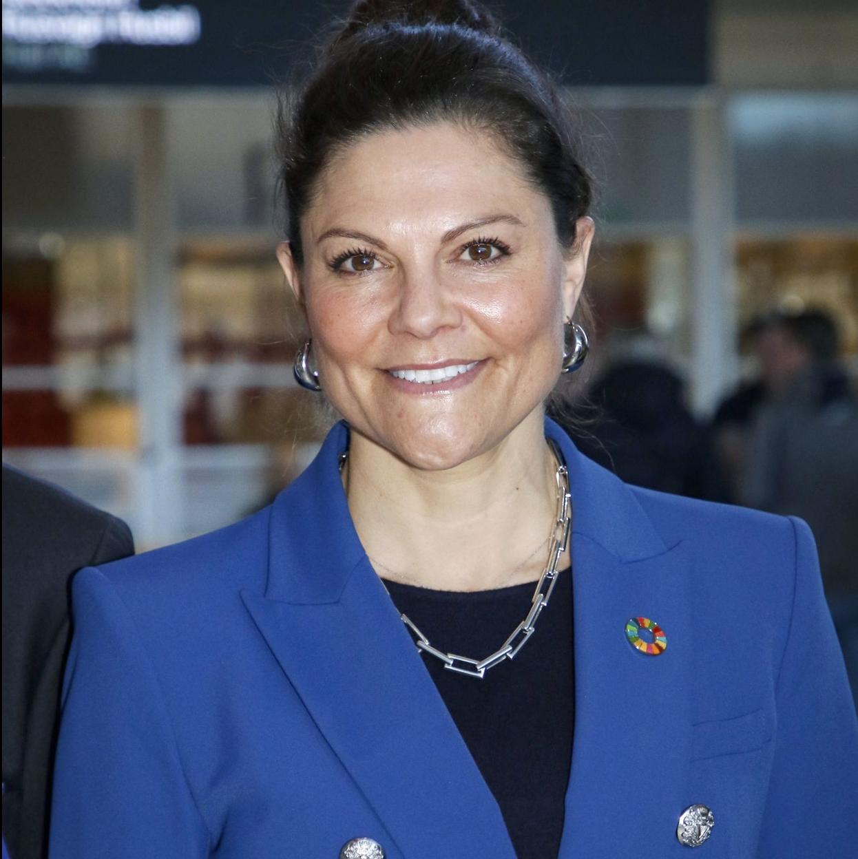 Victoria de Suecia con un teja de color azul.